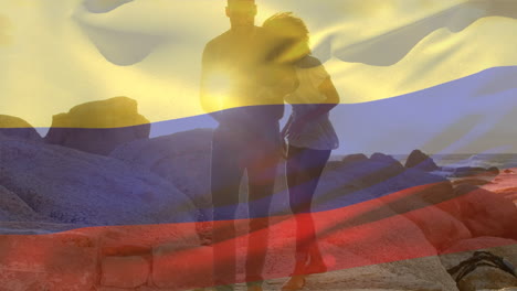 animación de la bandera de colombia sobre una pareja afroamericana en la playa