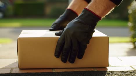 a delivery person carefully sets a sealed package on the doorstep of a suburban home. the bright sunlight casts shadows on the scene, emphasizing the peaceful neighborhood.