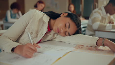 tired student sleeping at desk in classroom