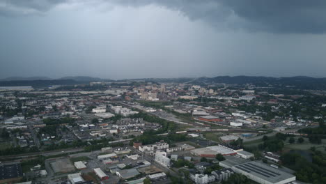 aerial hyperlapse of downtown chattanooga during the day with rainstorm in the background and traffic and trains in the foreground