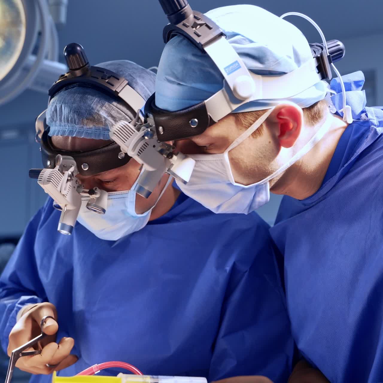 Neurocirujanos con gafas de realidad aumentada trabajando en el quirófano. Un médico ayuda a colocar los instrumentos
