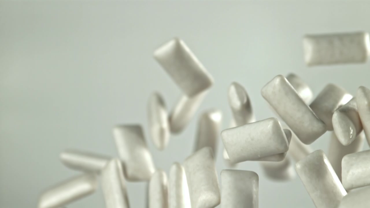 Pezzi di chewing gum bianchi che cadono al rallentatore
