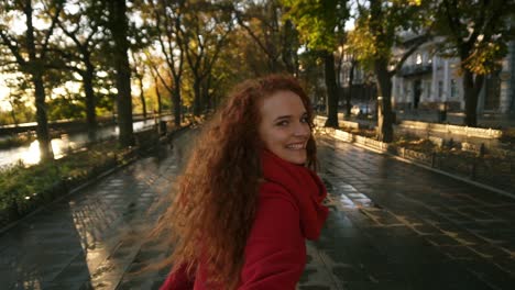 Back-View-Of-Young-Woman-Joyfully-Running-In-A-Colorful-Autumn-Park-By-Alley,-Enjoying-Autumn-Foliage,-Turns-Around-Joyfully-Smiling-At-Camera