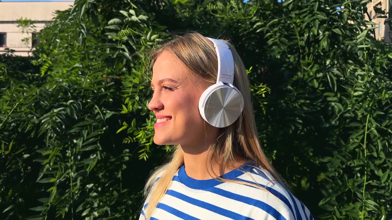 Giovane donna che ascolta musica con le cuffie all'aperto