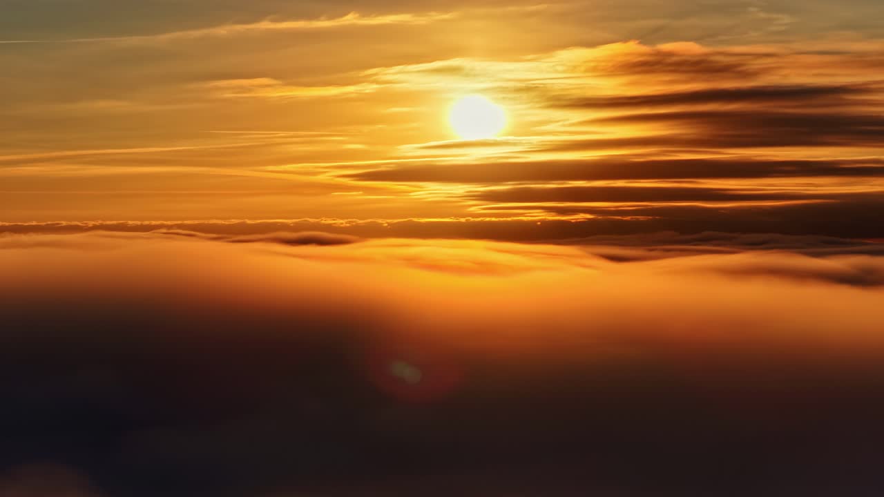 Luftfoto av glødende solnedgang over tykke skylag og dramatisk gyllen himmel