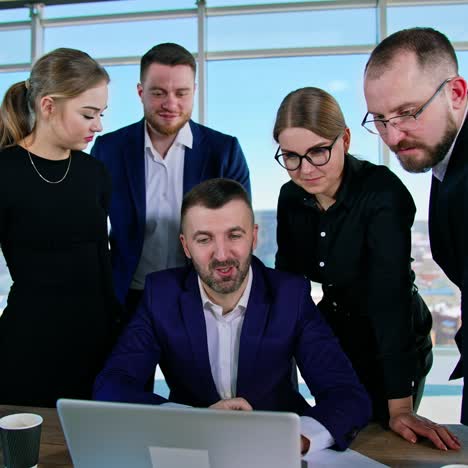 positive entrepreneurs work together in office. group of young business men and women look at a laptop and discuss new ideas. business meeting