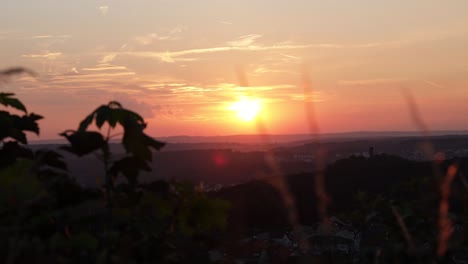 timelapse of the sunset over forbach, france. the camera captures the changing colors of the sky as the sun sets behind the schlossberg castle