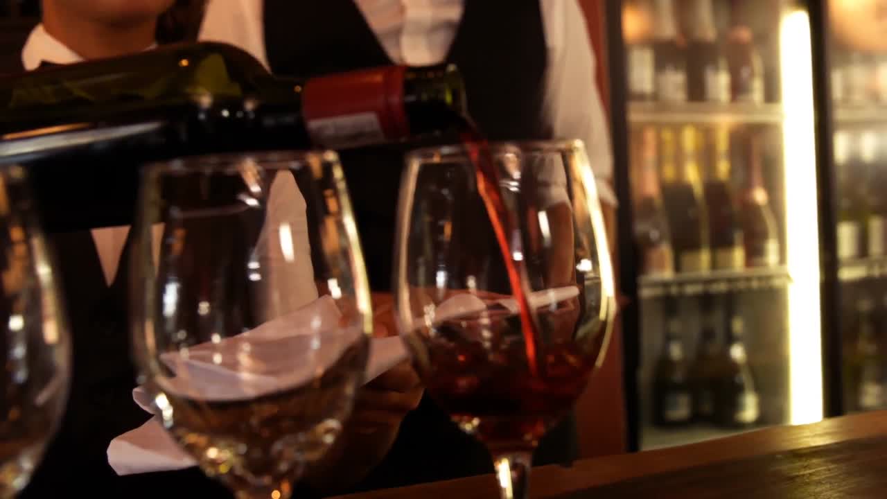 Busto di cameriera che versa vino rosso in un bicchiere