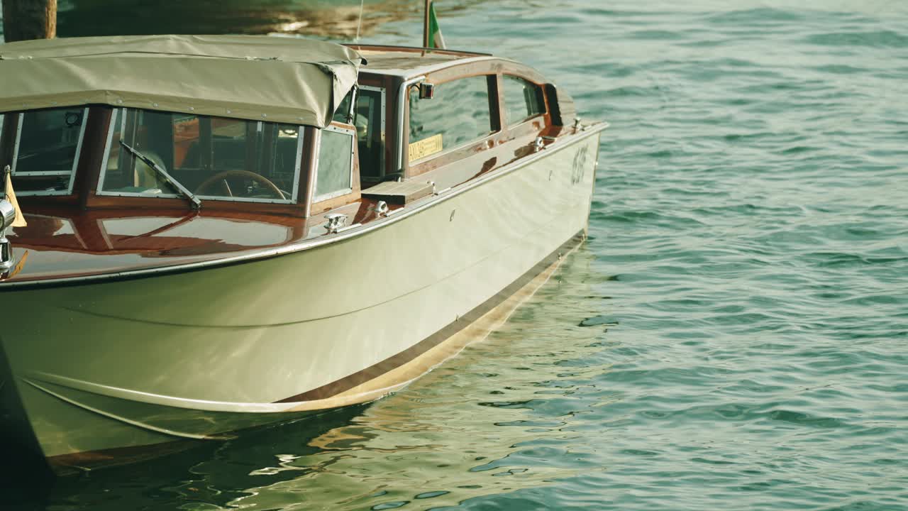 Un tradizionale taxi acqueo vecchio stile ormeggiato a Venezia che dondola in attesa del prossimo incarico.