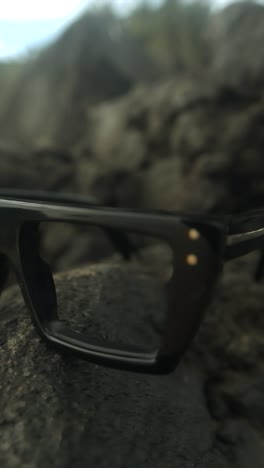 glasses resting on a rock surface with a soft focus, showcasing nature and simplicity