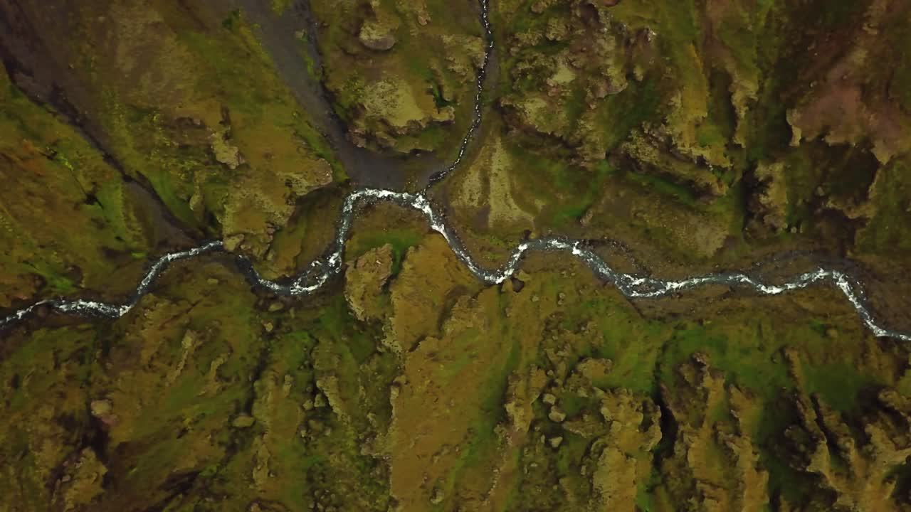 vista superior aérea sobre un río que fluye y texturas y patrones naturales del terreno islandés