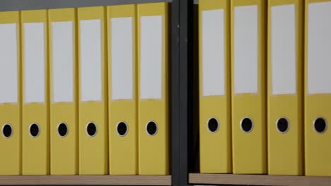 rows of yellow office binders on shelves