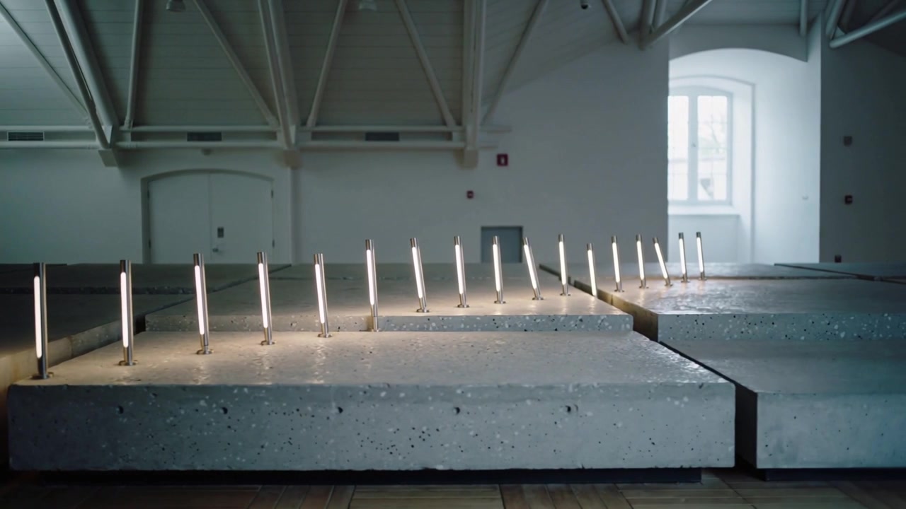 Timer starting sequence, LED tubes moving right across concrete plinths in gallery