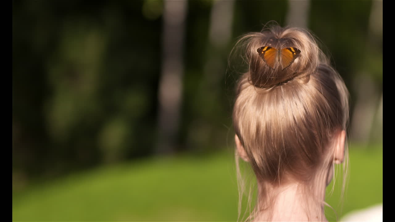 Butterfly lands on woman's head close-up