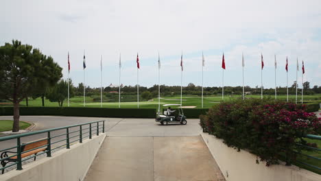 Driving-a-Caddy-Cart-around-Golf-Course-Facility-with-Green-Fields-for-Sports-under-Open-Blue-Sky