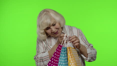 Ältere-Großmutter-Hebt-Einkaufstüten-Hoch,-Feiert,-Zufrieden-Mit-Dem-Kauf,-Rabatt.-Chroma-Key