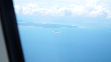 Atemberaubende-Aussicht-Auf-Wolken-Und-Berge-Aus-Einem-Flugzeugfenster