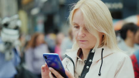 a sad middle-aged woman uses a smartphone in a crowd of people loneliness and depression concept
