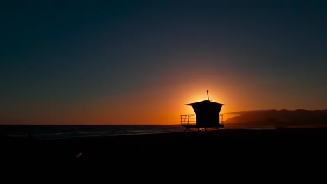 Lenta-Puesta-De-Sol-Lateral-En-La-Playa-Estatal-De-San-Buenaventura-Con-Casa-De-Salvavidas:-Torre-En-Ventura,-California,-Estados-Unidos