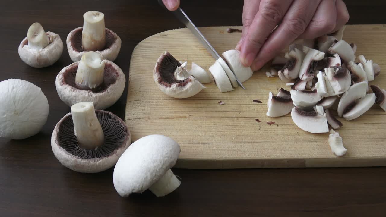 주방 칼을 들고 질과  버섯을 잘라내는 여자