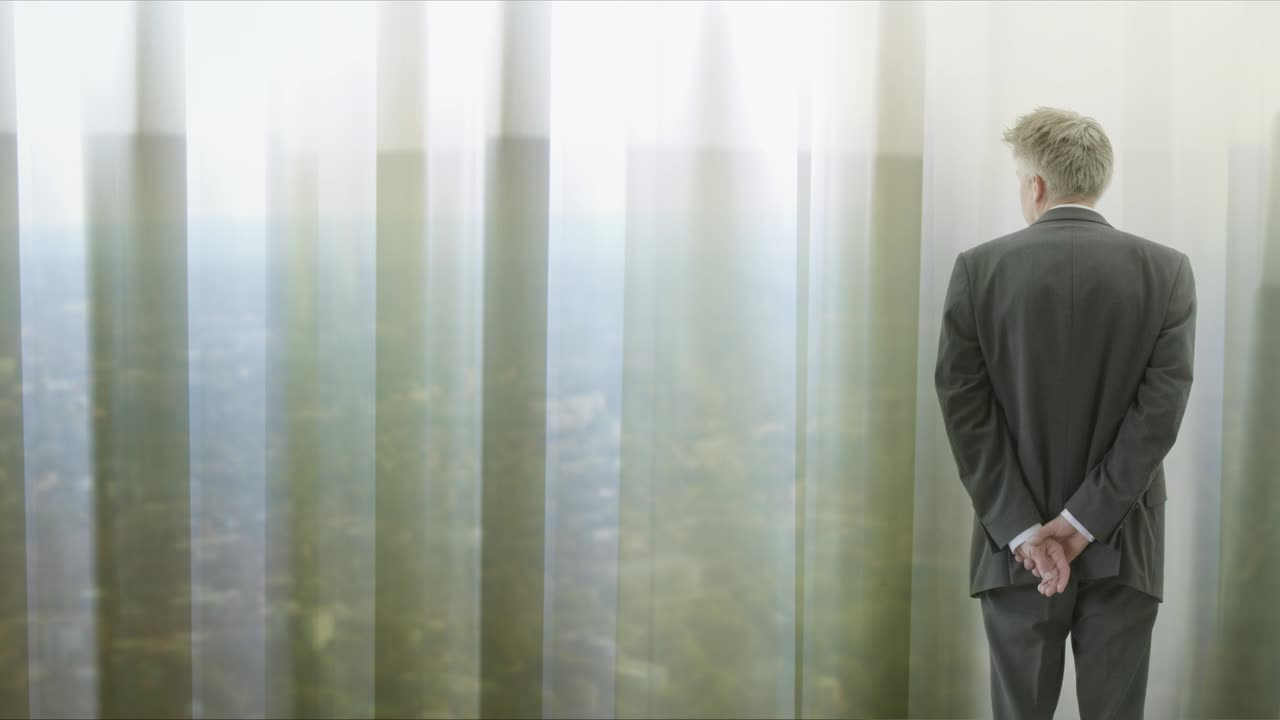 커튼을 통해 보는 외로운 사업가