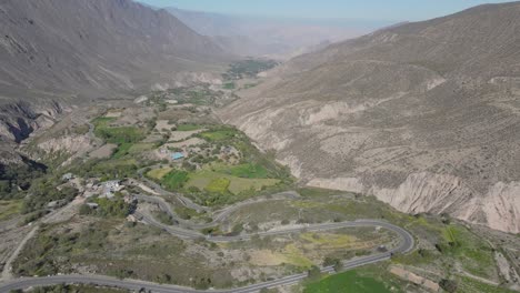 winding road with green fields and mountains of the chuquibamba district taken from the air