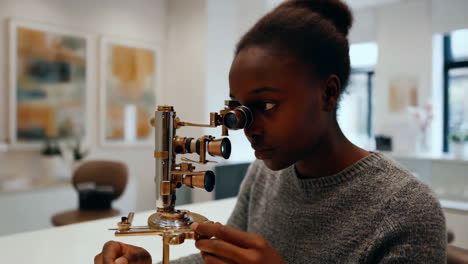 woman examining an antique microscope