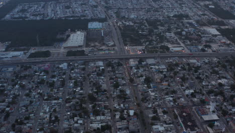 Reveal-shot-of-the-highway-crossing-Playa-del-Carmen.-Aerial-view-during-sunset