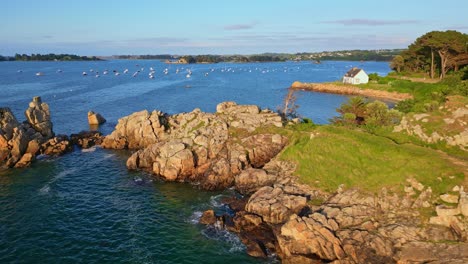 rocky coast and harbor at port blanc, plage le voleur, golden hour, brittany, france. aerial drone low-altitude
