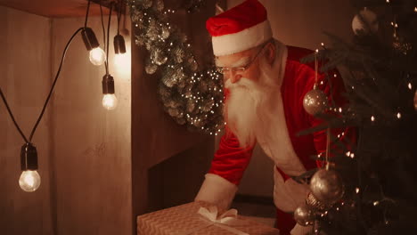 Santa-Trae-Un-Regalo-A-Los-Niños-La-Noche-De-Navidad-Y-Lo-Coloca-Cerca-Del-árbol-De-Navidad-En-La-Casa-De-Los-Niños.-La-Cámara-Monitorea-La-Entrega-Del-Regalo-Debajo-Del-árbol.-Imágenes-4k-De-Alta-Calidad