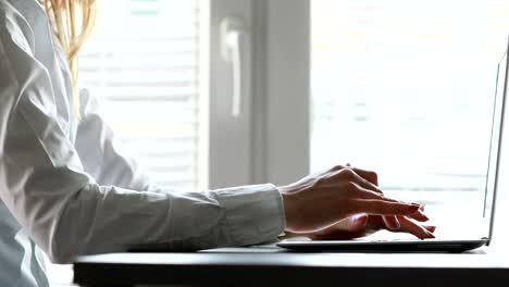 woman typing at laptop then stops then taps