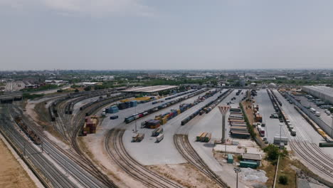 Imágenes-Aéreas-Amplias-De-Un-Centro-De-Logística-Industrial-Con-Camiones-Que-Mueven-Contenedores-En-Bari,-Italia