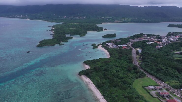 Ripresa Orizzontale in Avanzamento da un'Angolazione Obliqua Elevata sopra Acque Costiere Turchesi, Isole Boscose e la Costa vicino alla Baia di Kabira, Okinawa, Giappone