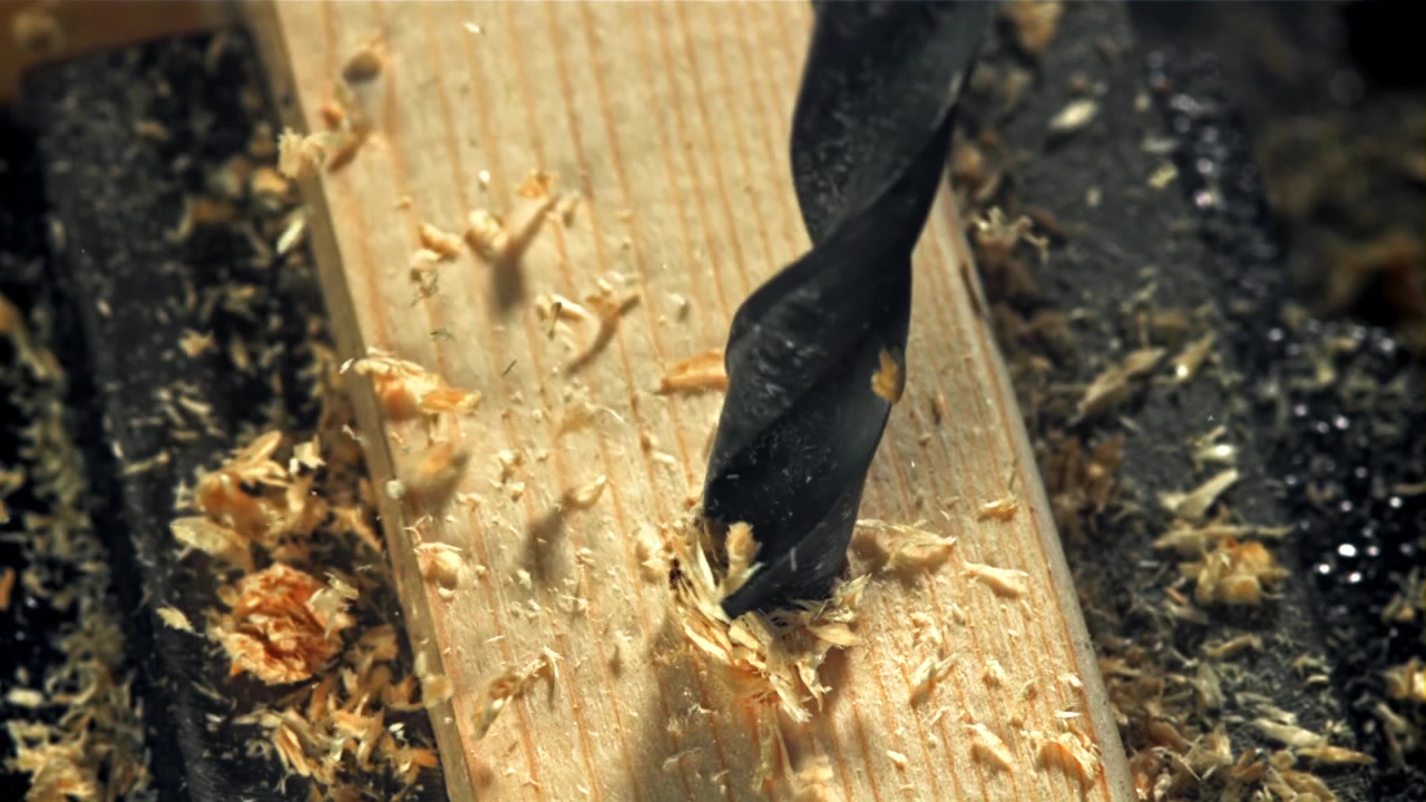 Nahaufnahme eines Bohrers, der in ein Holzstück bohrt