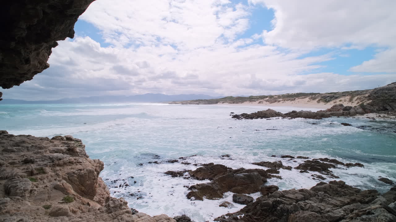 Waves roll into rocky bay and view toward Die Plaat in Walker Bay nature reserve