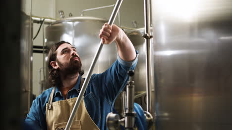 homme qui nettoie les machines de brassage