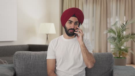 hombre indio sikh enojado gritando en el teléfono