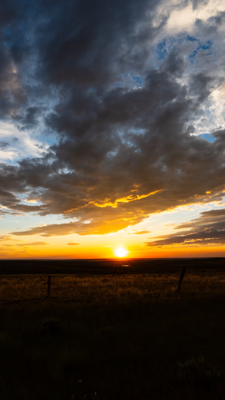 Warmes Sonnenuntergangslicht, das Sturmwolken über einer malerischen Landschaft mit dramatischem Himmel und natürlicher Schönheit beleuchtet