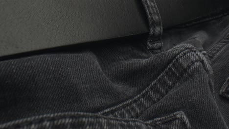 Black-leather-belt-in-black-jeans-of-man-pants,-dolly-backward