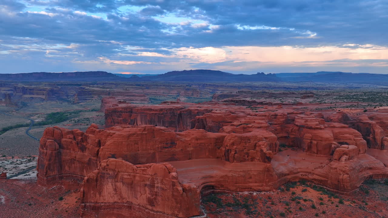 Stiger opp over den steinete ørkenen ved solnedgang. Avslører utsikten over de spektakulære canyonene i Arches National Park i Utah, USA