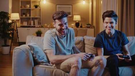 happy father and son playing video games at home