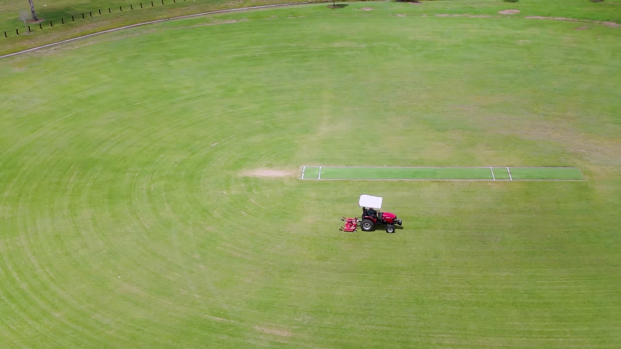tractor cortando un gran campo de deportes