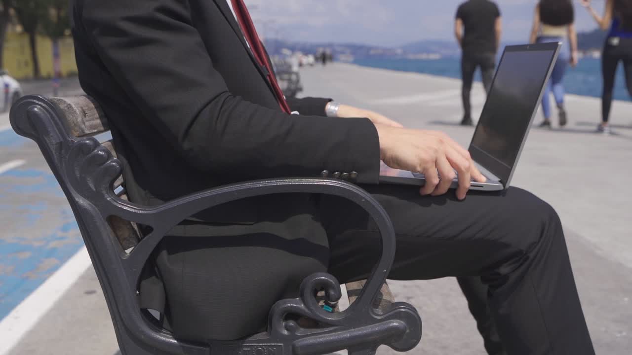 해변에서 노트북을 사용하는 남자. 슬로우 모션.