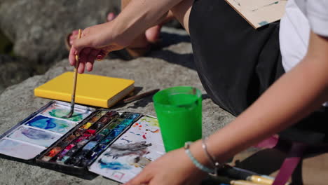 woman painting outdoors with watercolors