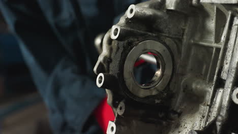 close-up of an engine being worked on by a mechanic with red gloves, focusing on the intricate parts and tools involved in the maintenance process