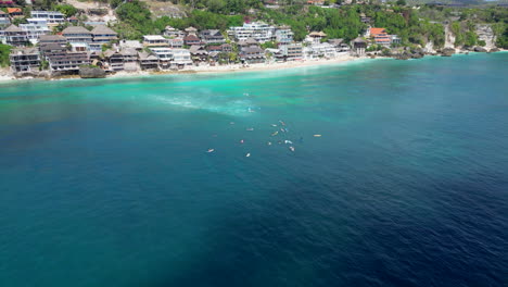 Un-Grupo-De-Surfistas-Esperan-La-Próxima-Ola-En-La-Playa-De-Bingin,-Indonesia