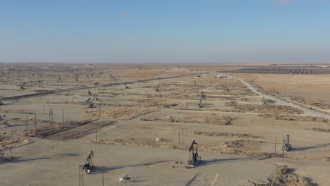 drone flight forward over oil pumps in central california, usa