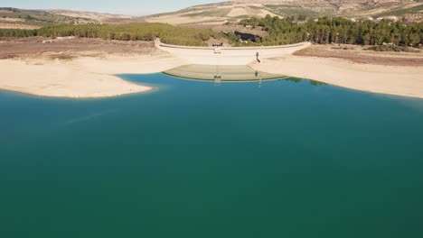 Flight-over-the-water-of-the-reservoir-and-plane-revealing-the-reservoir-dam