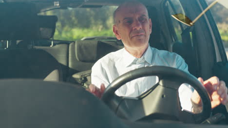 elderly man sings happily while waiting in the car