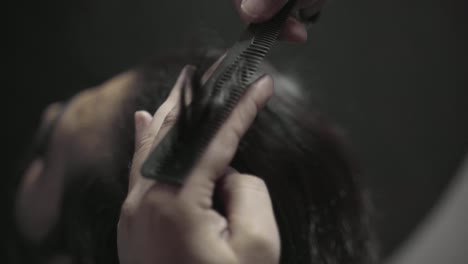 closeup of hairdresser styling mens hair in a barbershop in pakistan